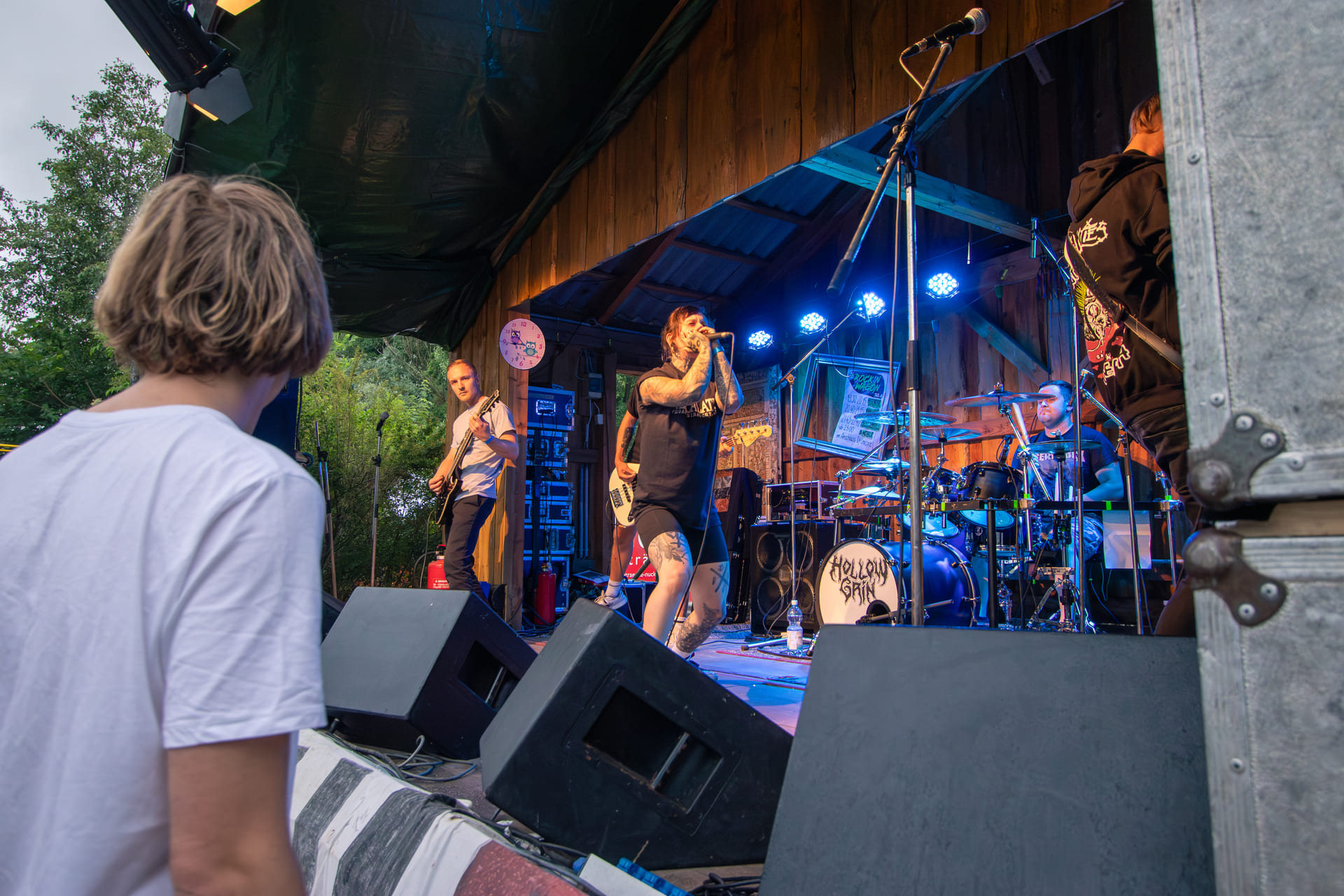 Eine Band performt auf einer Bühne mit einem Mann im Vordergrund.