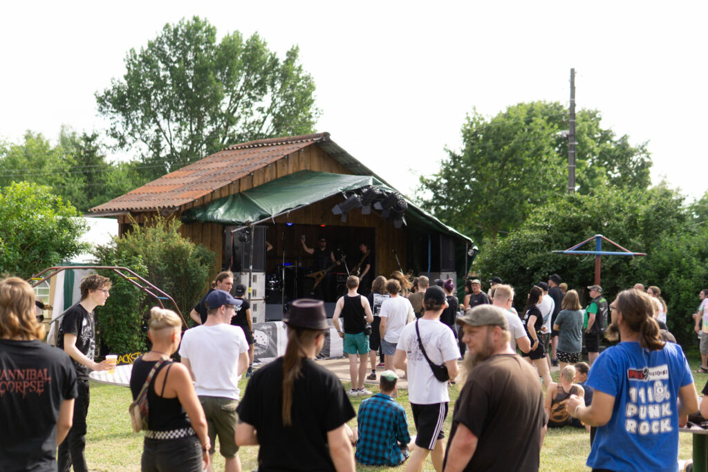 Eine Gruppe von Menschen steht vor einer Bühne.